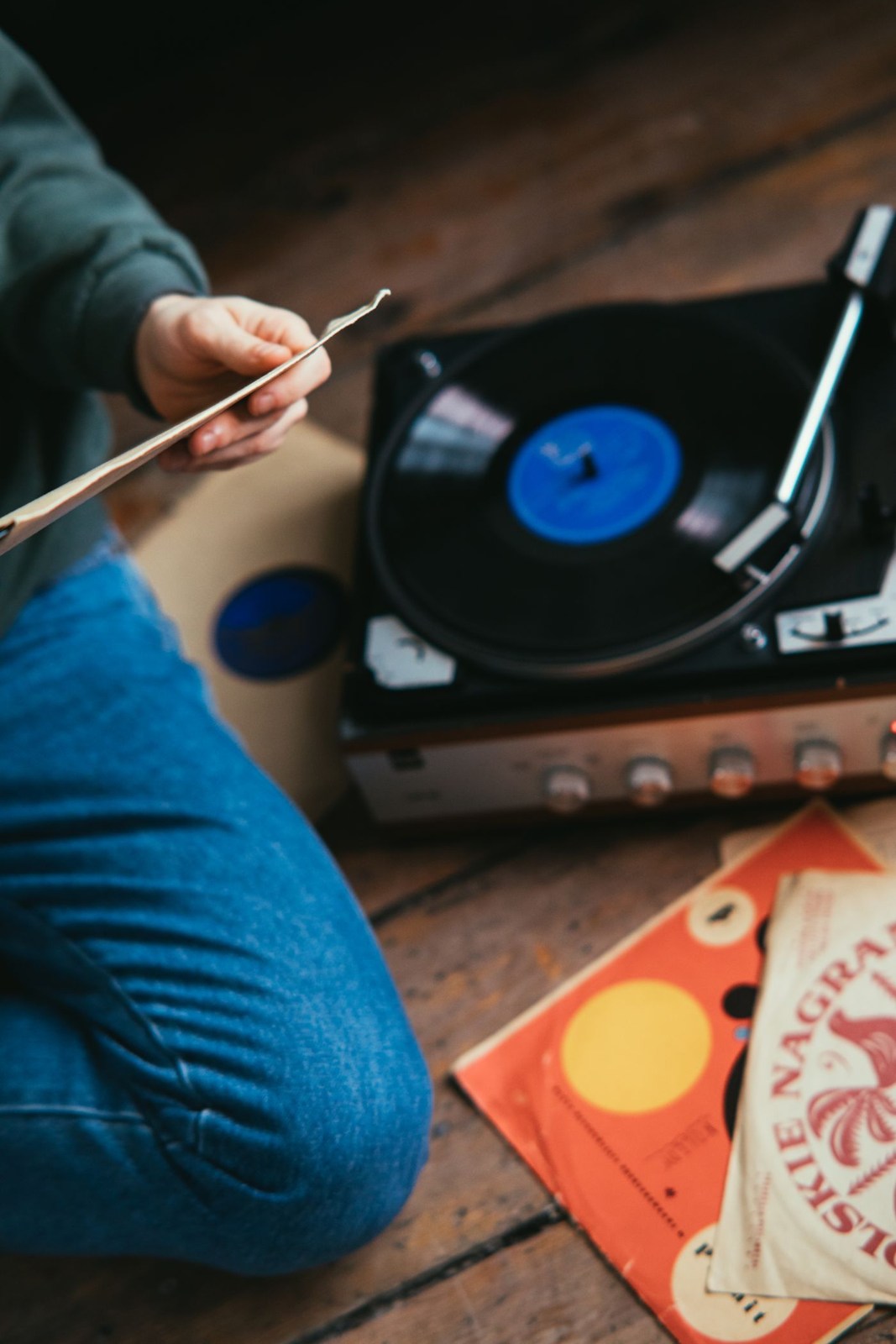 Eine Person neben einem Plattenspieler und Schallplatten