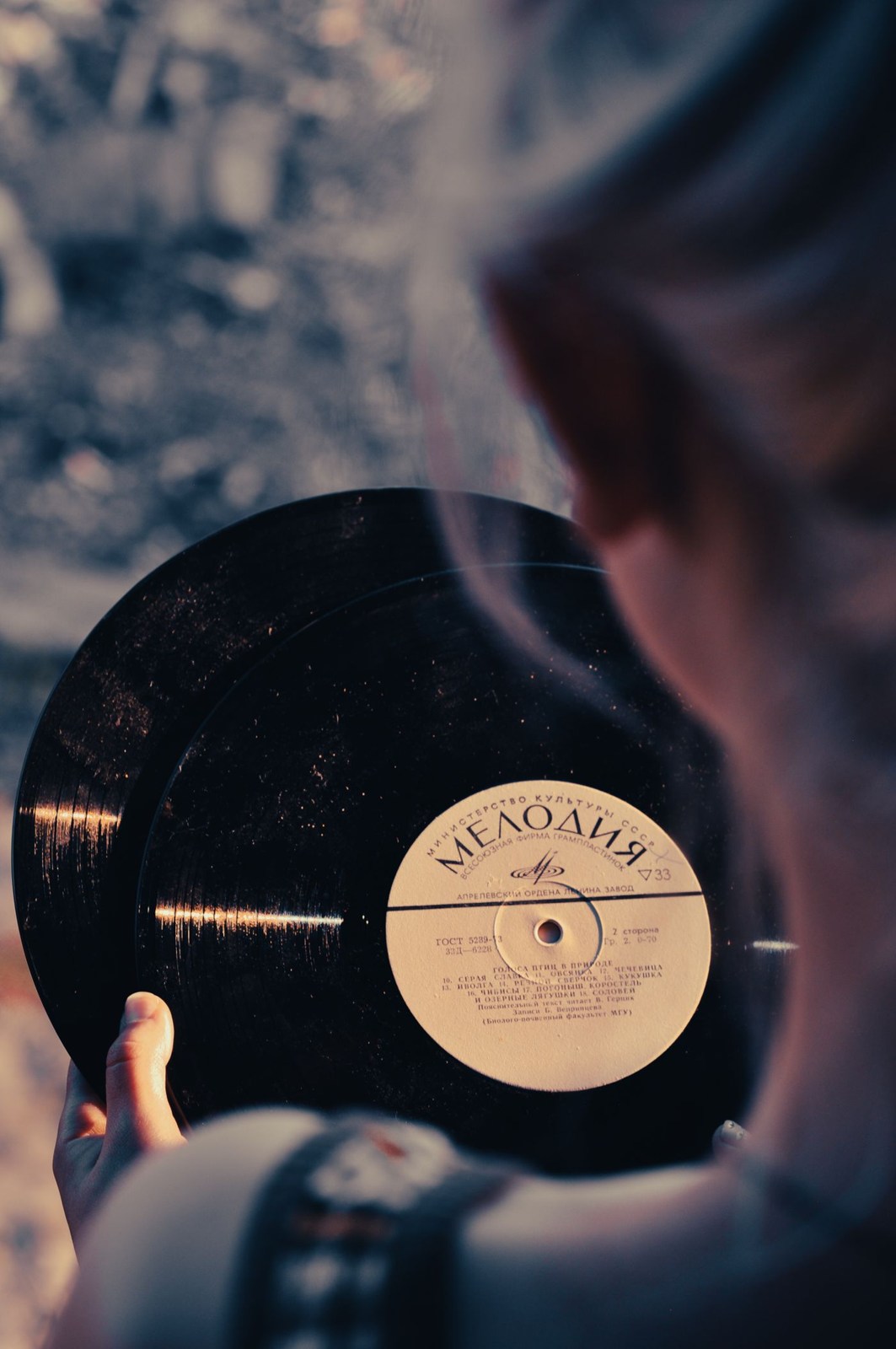 A person holding a black record by its edge