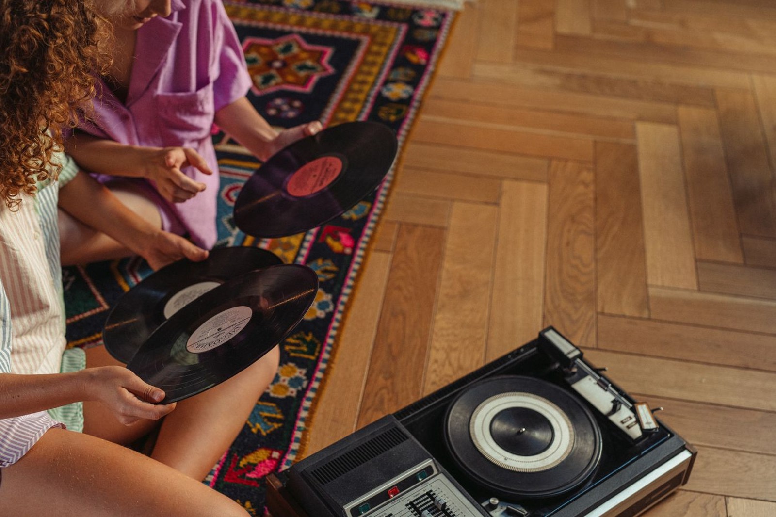 Zwei Personen sehen neben einem Plattenspieler Schallplatten durch